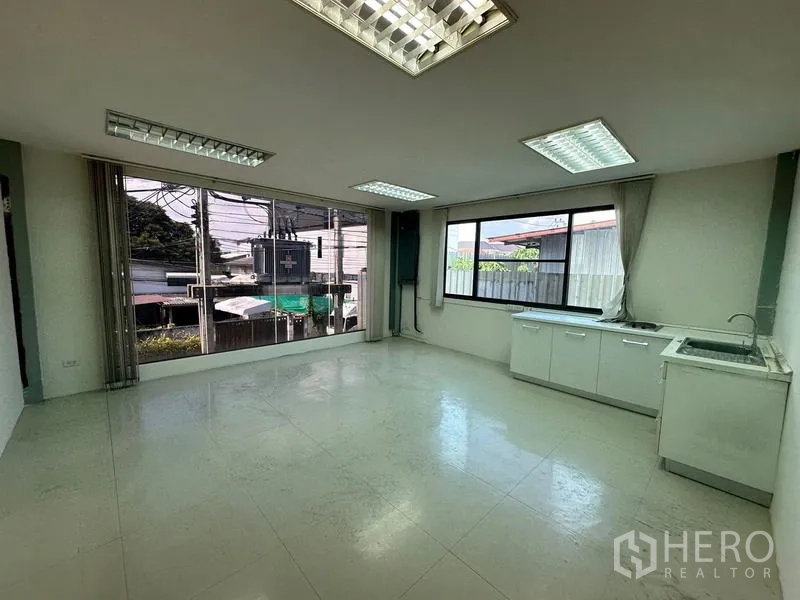 Office Space for rent - Pantry room with built-in cabinets, sink, and wide windows.