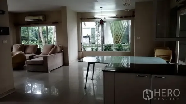 บ้าน ให้เช่าในLat Krabang, Bangkok - โถงรับแขก–ทานอาหารมองเห็นสวนผ่านหน้าต่างบานกว้างและประตูกระจก