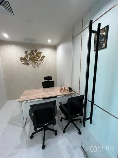 Office Space for rent - Private manager’s office with desk, two guest chairs and glass partition.