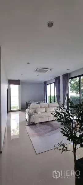 บ้าน ให้เช่าในLat Krabang, Bangkok - ห้องนั่งเล่นกว้าง โปร่งด้วยหน้าต่างบานใหญ่ เฟอร์นิเจอร์ครบ มองเห็นสวน