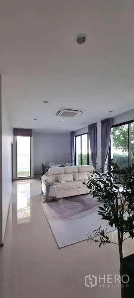 บ้าน ให้เช่าในLat Krabang, Bangkok - ห้องนั่งเล่นกว้าง โปร่งด้วยหน้าต่างบานใหญ่ เฟอร์นิเจอร์ครบ มองเห็นสวน