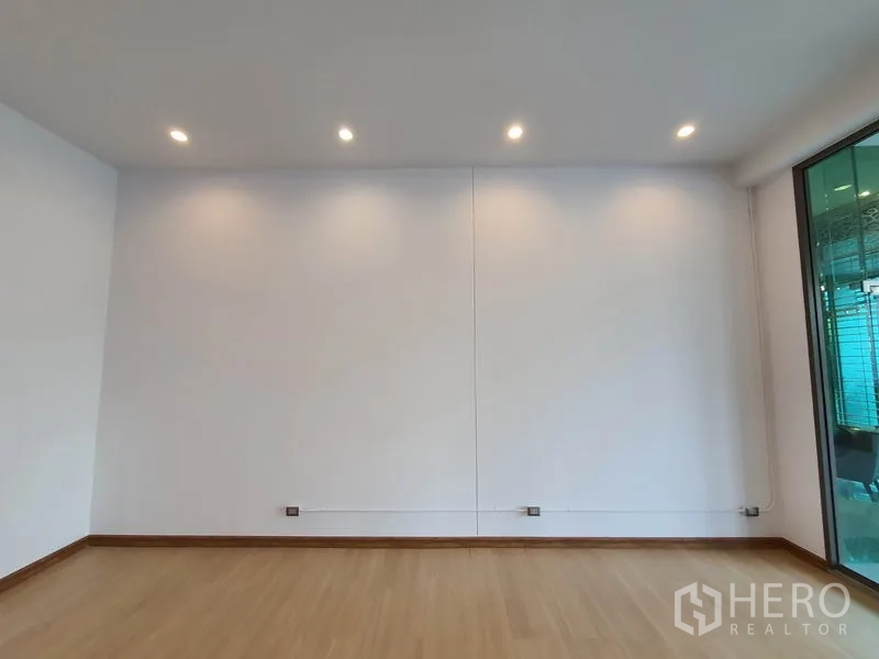 พื้นที่ขายปลีก ให้เช่าในWatthana, Bangkok - ภายในยูนิตค้าปลีกสว่าง ผนังสีขาว พื้นลามิเนตลายไม้ และไฟดาวน์ไลท์