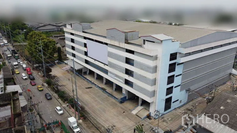 货栈 出租在Phra Pradaeng, Samut Prakan - 多层仓库建筑临主路的航拍图。
