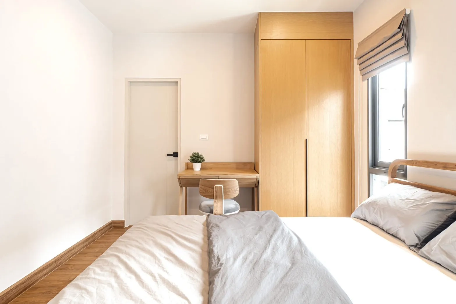 Detached House for rent in Bang Phli, Samut Prakan - Bedroom view toward work desk and tall wood wardrobe beside window.