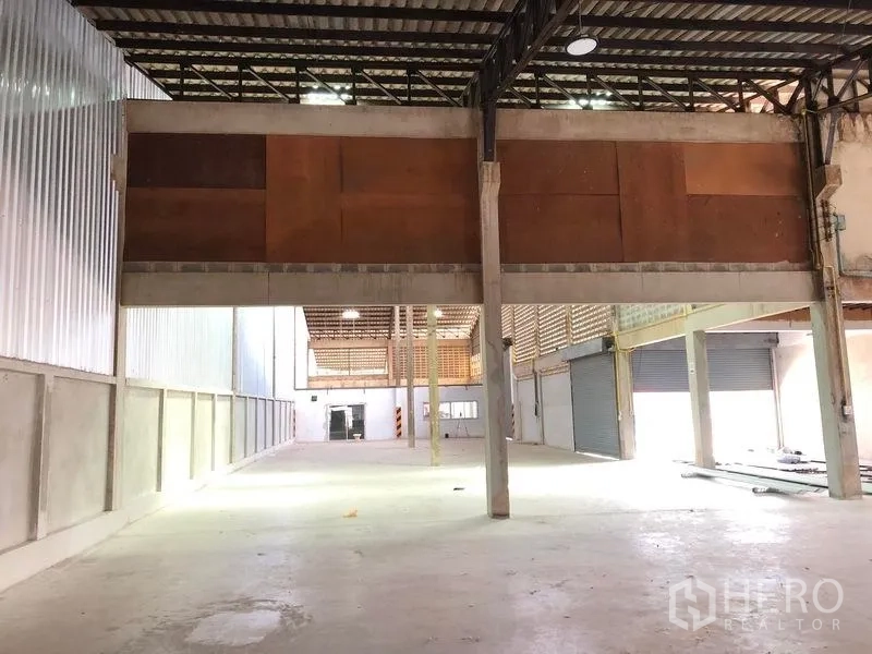 货栈 出租在Pathum Thani - 室内带夹层储物、钢结构屋架和卷帘门。