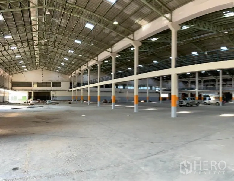 Warehouse for rent in Khlong Sam Wa, Bangkok - Expansive high-clearance warehouse hall with steel truss roof, skylights and wide open loading area.