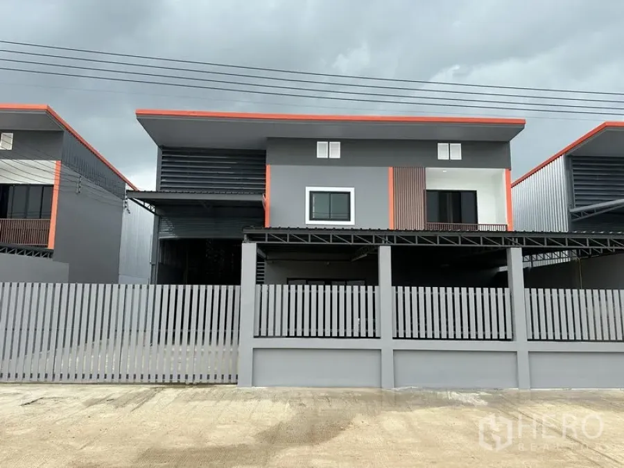 คลังสินค้า ให้เช่าในLam Luk Ka, Pathum Thani - ด้านหน้าโกดังสองชั้นสไตล์โมเดิร์น ผนังเทา คาดส้ม พร้อมรั้วรอบคลุม