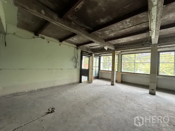 办公空间 出租在Bang Rak, Bangkok - 开放式转角区域，整面窗与门口，窗外绿色景观。