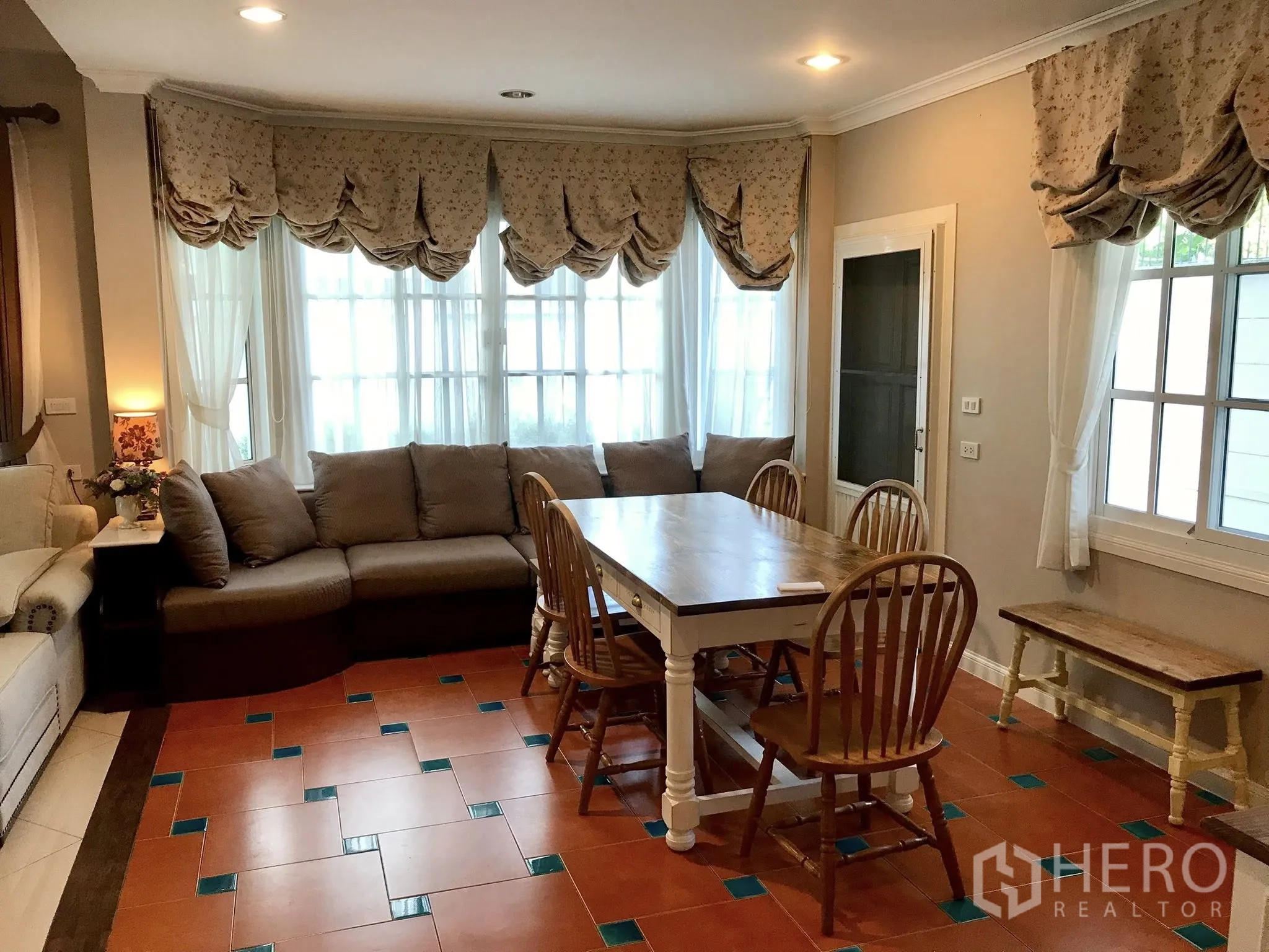 Detached House for rent in Mueang Samut Prakan, Samut Prakan - Dining nook with wooden table and chairs beside a bay window with built-in bench.