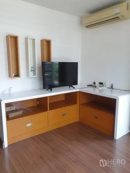 ทาวน์เฮาส์ ให้เช่าหรือขายในYan Nawa, Bangkok - มุมทีวีพร้อมตู้บิวท์อินรูปตัวแอล พื้นไม้ และเครื่องปรับอากาศติดผนัง