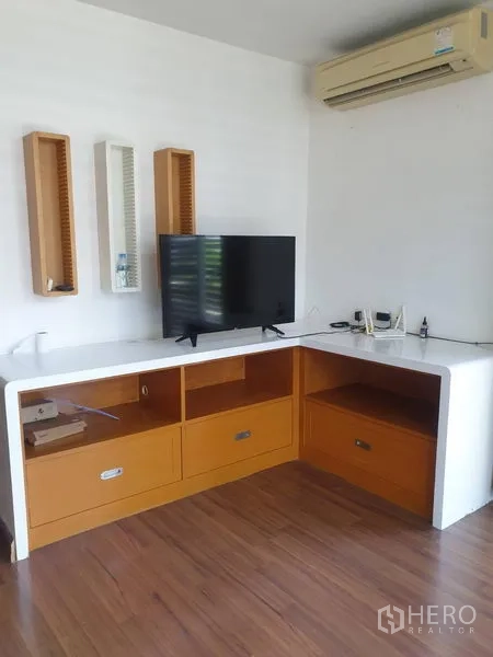 ทาวน์เฮาส์ ให้เช่าหรือขายในYan Nawa, Bangkok - มุมทีวีพร้อมตู้บิวท์อินรูปตัวแอล พื้นไม้ และเครื่องปรับอากาศติดผนัง