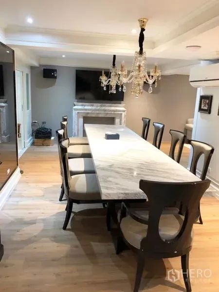 Shophouse for rent or sale in Chatuchak, Bangkok - Formal dining room with long marble table, upholstered chairs and crystal chandelier.