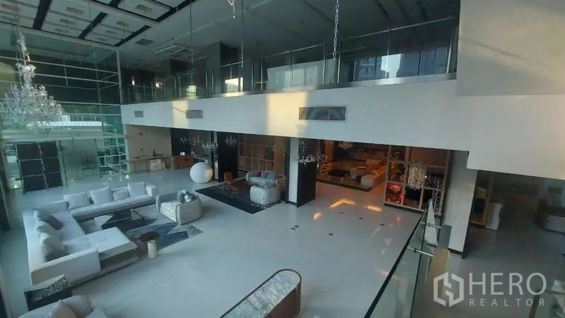 零售空间 出租在Watthana, Bangkok - 从夹层俯瞰挑高展厅与玻璃栏杆