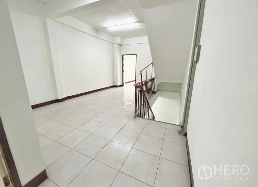 店屋 for rent in Suan Luang, Bangkok - 楼层平台空间，瓷砖地面、白色墙面与楼梯。