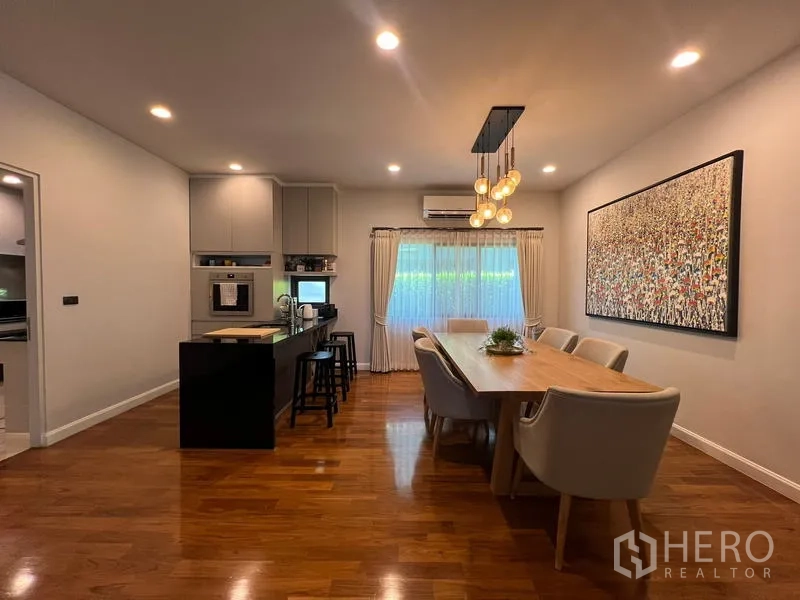 Detached House for rent in Bang Kapi, Bangkok - Dining space with pendant lights, six-seat table and adjacent kitchen island.
