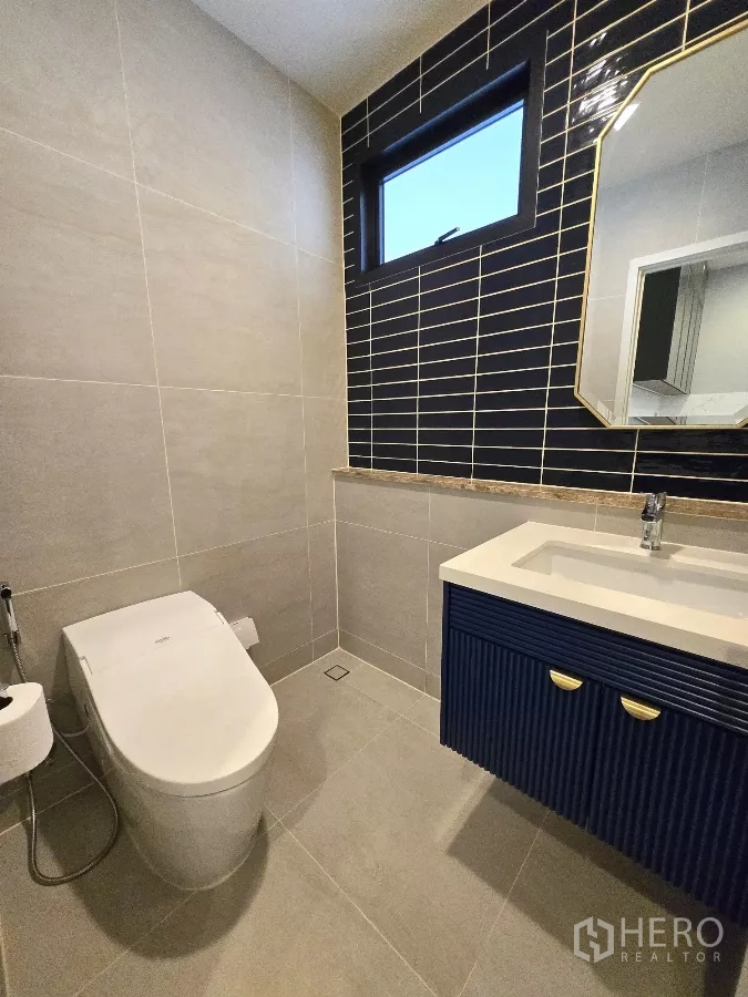 Detached House for rent in Bang Phli, Samut Prakan - Powder room with navy vanity and black tile feature wall.