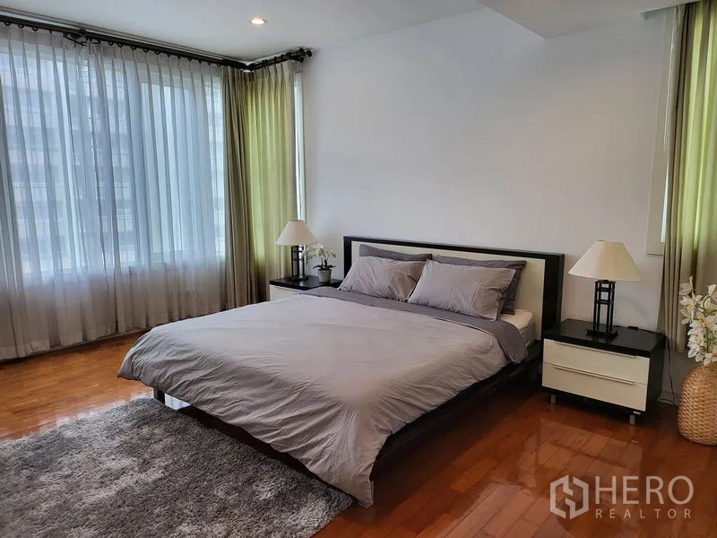 คอนโด ให้เช่าในKhlong Toei, Bangkok - ห้องนอนมาสเตอร์กว้าง เตียงคิงไซส์ โต๊ะข้างเตียง และหน้าต่างกระจกสูง