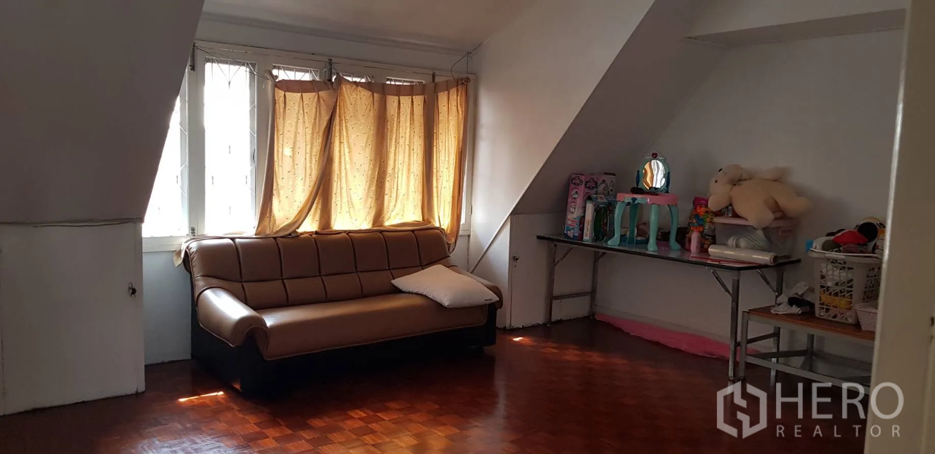 ทาวน์เฮาส์ ให้เช่าในKhlong Toei, Bangkok - มุมนั่งเล่นชั้นบน มีโซฟา พื้นปาร์เกต์ และหน้าต่างใต้เพดานลาด