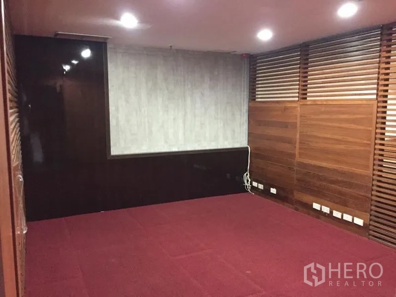 Office Space for sale in Watthana, Bangkok - Private meeting room with wood wall panels, slatted divider, red carpet and recessed lights.