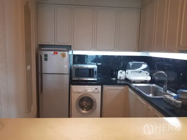 คอนโด ให้เช่าในKhlong Toei, Bangkok - ครัวรูปตัวแอล ตู้สีขาว ท็อปหินสีดำ พร้อมตู้เย็น ไมโครเวฟ อ่างล้างจาน และเครื่องซักผ้า