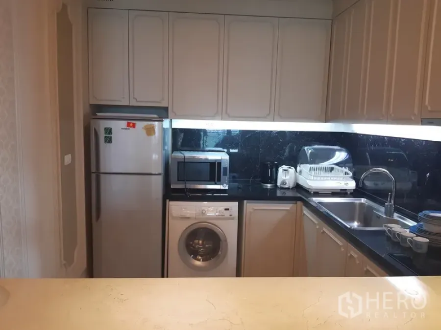 คอนโด ให้เช่าในKhlong Toei, Bangkok - ครัวรูปตัวแอล ตู้สีขาว ท็อปหินสีดำ พร้อมตู้เย็น ไมโครเวฟ อ่างล้างจาน และเครื่องซักผ้า