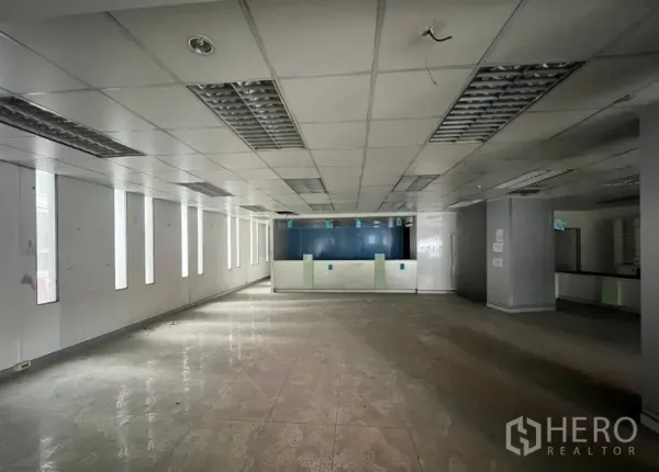 店屋 出租或出售在Khlong Toei, Bangkok - 一层大型零售空间，吊顶、瓷砖地面与前台服务柜台。