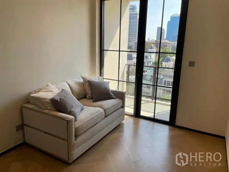 คอนโด ขายในWatthana, Bangkok - ห้องนั่งเล่นอบอุ่น โซฟาและประตูกระจกเปิดสู่ระเบียง