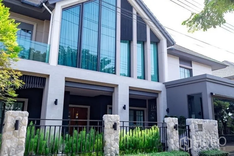 Detached House for sale in Pak Kret, Nonthaburi - Front elevation of the detached house with soaring glass gable and secure fence.