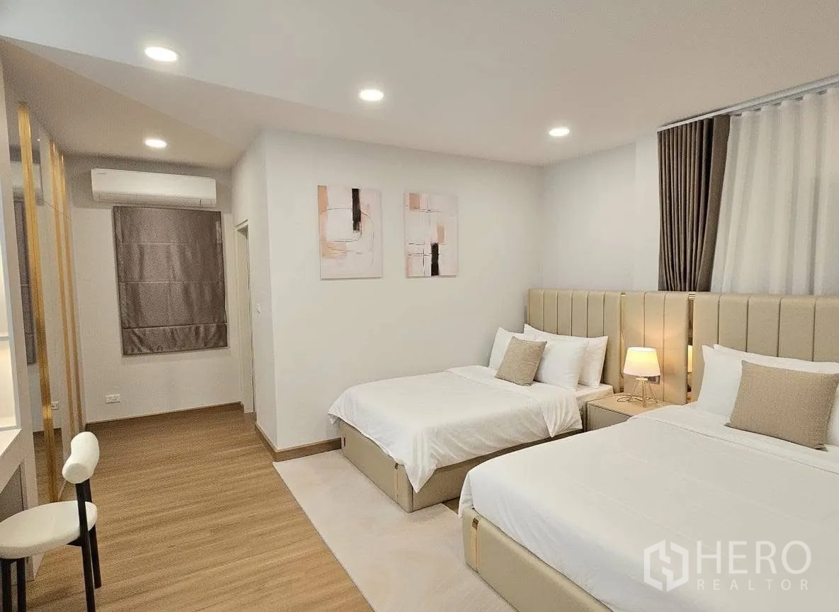 Detached House for rent or sale in Bang Phli, Samut Prakan - Spacious guest bedroom featuring two beds, recessed lights, vanity desk and air conditioning.