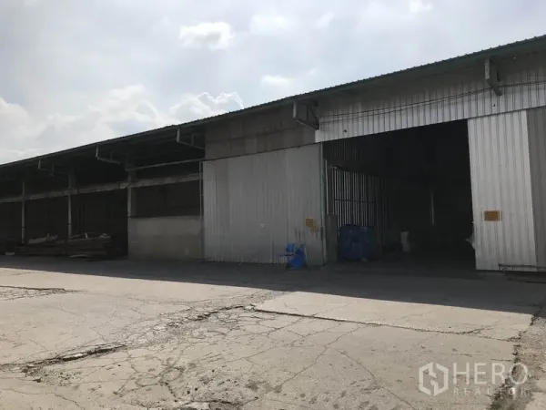 货栈 出租在Mueang Pathum Thani, Pathum Thani - 金属板外立面仓库，设多处装卸口与宽阔车道。
