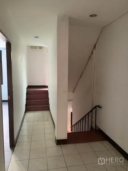 店屋 出租在Watthana, Bangkok - 室内走廊铺砖，通往楼梯和上层空间。