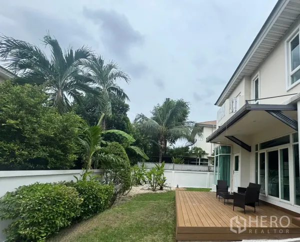 独立式住宅 出租在Prawet, Bangkok - 后院木质露台配户外座椅，周围热带棕榈花园。