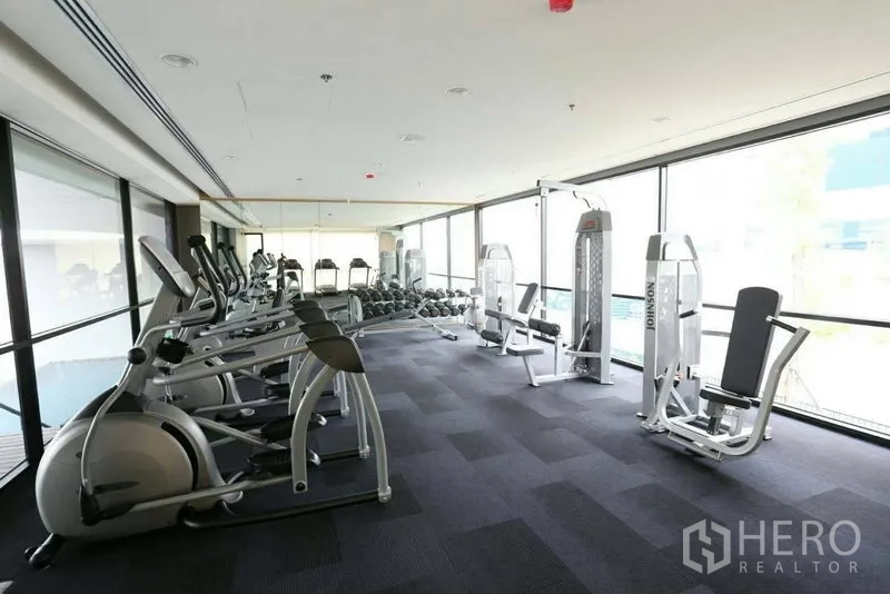 Condominium for sale in Bang Rak, Bangkok - Condominium fitness center with cardio machines, free weights and floor-to-ceiling windows.