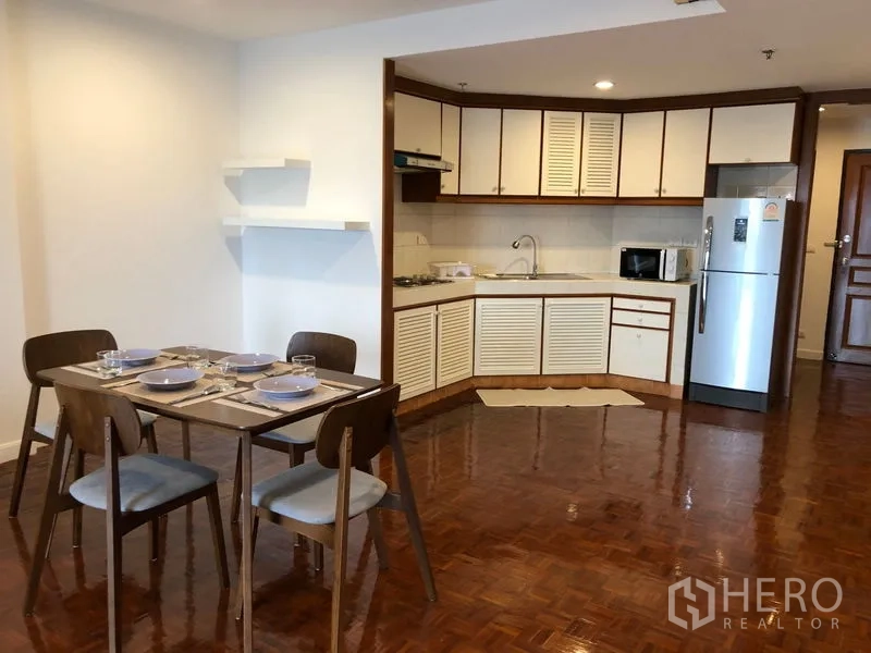 Condominium for rent or sale in Sathon, Bangkok - Dining corner beside the kitchen with a four-seat table and wall shelves.
