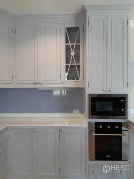 独立式住宅 出租在Bang Na, Bangkok - 高柜一体式微波炉与烤箱，浅灰色门板。