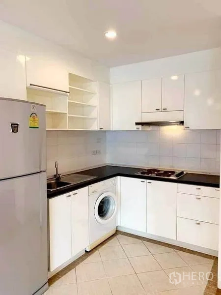 คอนโด ให้เช่าในSathon, Bangkok - ครัวรูปตัวแอลโทนขาว เตา เครื่องดูดควัน ตู้เย็น ท็อปสีดำ พร้อมเครื่องซักผ้าในห้อง