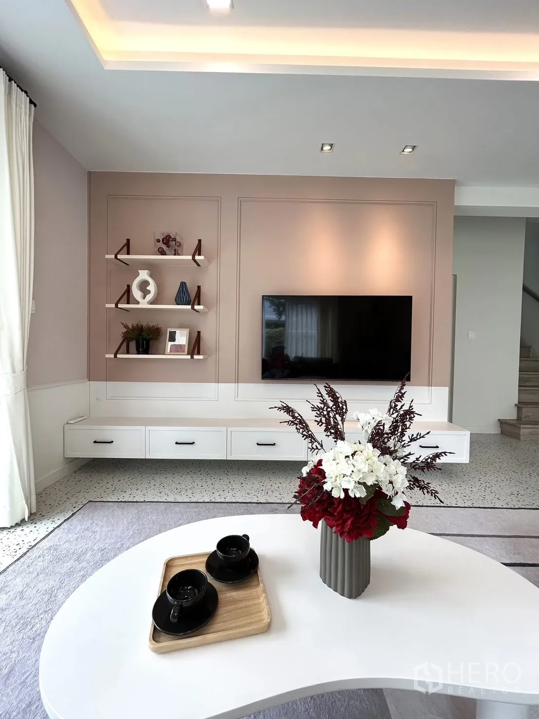 Detached House for rent in Bang Phli, Samut Prakan - TV wall with floating cabinet and shelves, flowers on a coffee table.