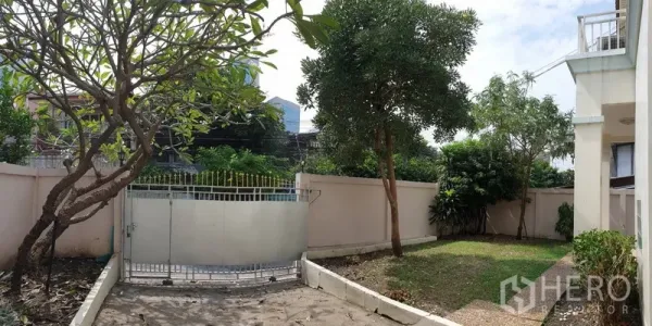 Detached House for rent in Khlong Toei, Bangkok - Gated front yard with lawn, trees and a private driveway of the Sukhumvit rental house.