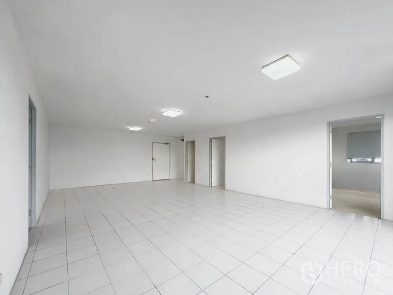 คอนโด ขายในBang Na, Bangkok - พื้นที่นั่งเล่นโล่งปูกระเบื้องสีขาว พร้อมประตูหลายบานไปยังห้องต่างๆ.