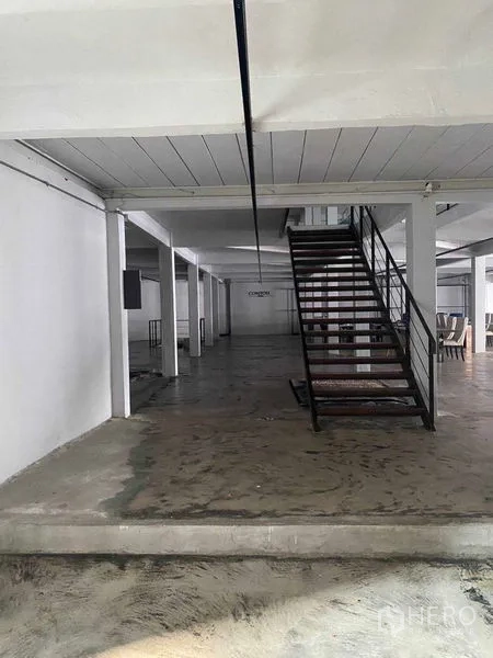 零售空间 出租在Bang Na, Bangkok - 工业风金属楼梯通向上层，周围为大空间。