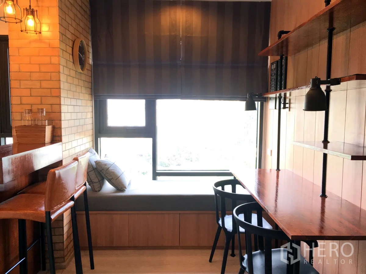 คอนโด ให้เช่าในKhlong Toei, Bangkok - มุมทานอาหารและทำงานริมหน้าต่าง มีชั้นวางของและผนังอิฐ ในคอนโดกรุงเทพฯ