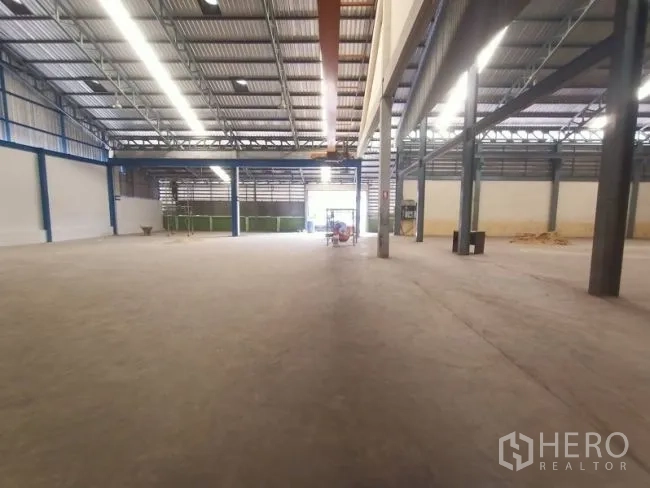 Factory for rent in Mueang Samut Sakhon, Samut Sakhon - Long view across the expansive factory floor toward a wide entrance and loading area.