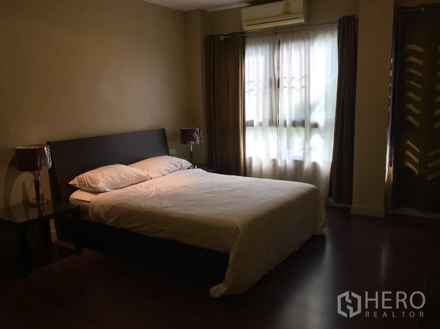 อพาร์ทเมนท์ ให้เช่าในKhlong Toei, Bangkok - ห้องนอนใหญ่เตียงคู่ ผ้าม่านทึบแสง และเครื่องปรับอากาศริมหน้าต่าง
