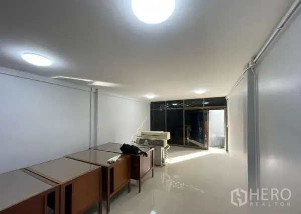 อาคารพาณิชย์ ขายในSuan Luang, Bangkok - ห้องชั้นล่างสว่าง พื้นกระเบื้องเงา ผนังสีขาว และประตูกระจกหน้า