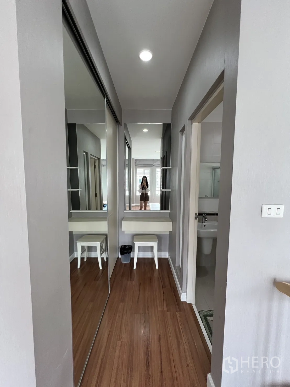 Detached House for rent in Bang Kapi, Bangkok - Walk-in wardrobe corridor with mirrored closets and a dressing table.