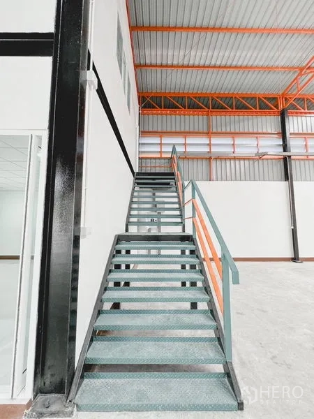 货栈 出租或出售在Khlong Luang, Pathum Thani - 仓库内两层办公室与楼梯的视角，靠近大开口。