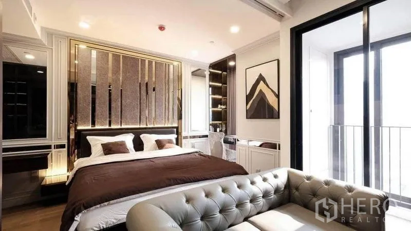 คอนโด ให้เช่าในBang Rak, Bangkok - ห้องนอนคอนโด 1 ห้องนอนสไตล์หรู พร้อมโซฟาทัฟท์ ผนังหัวเตียงเด่น และประตูกระจกออกสู่ระเบียง ย่านบางรัก กรุงเทพฯ