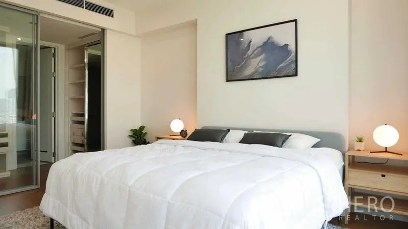 Condominium for rent in Sathon, Bangkok - Bedroom with king bed, bedside lamps and sliding glass door to closet.