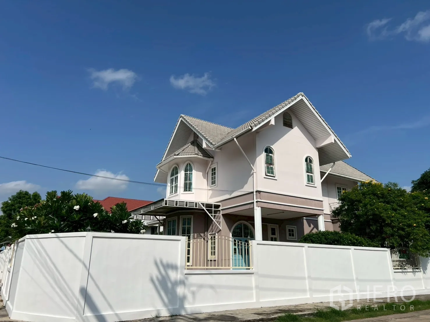 บ้าน ขายในPhra Khanong, Bangkok - มุมถนนของบ้านเดี่ยว 2 ชั้น มีกำแพงรั้ว หลังคาจั่วและหน้าต่างโค้ง