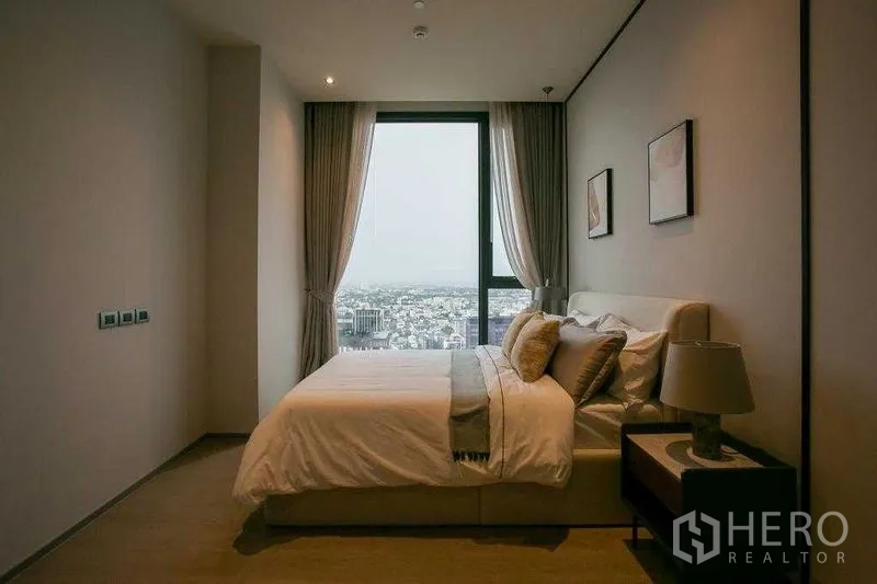 คอนโด ให้เช่าในWatthana, Bangkok - ห้องนอนแขก หน้าต่างบานใหญ่เห็นวิวสกายไลน์ โทนสีอบอุ่น